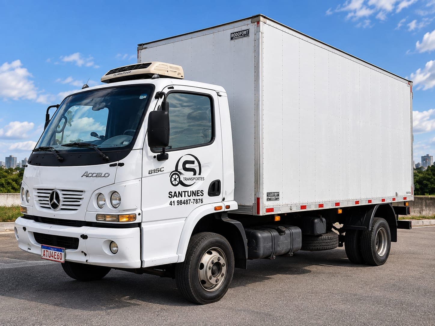 Caminhão baú Mercedes-Benz Accelo branco com a identidade visual da Santunes na porta.